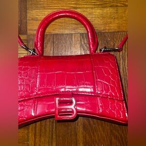 Red hourglass with silver balenciaga bag .